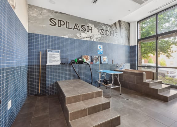 the entrance to thesplash zone with a bench and a table with a water hose