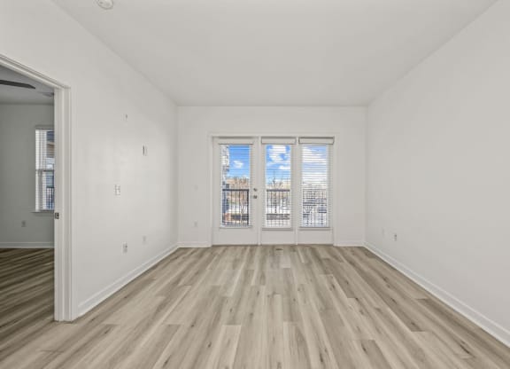 A room with a window and wooden flooring.