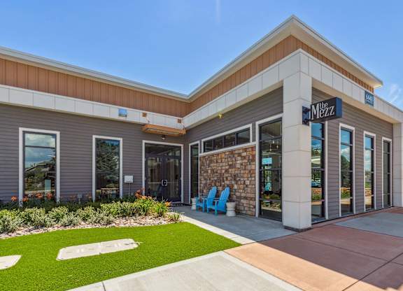 The Menza storefront with a blue chair in front.