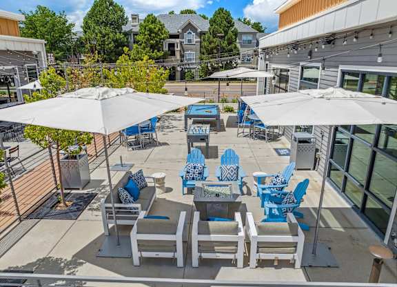 A patio with blue and white chairs and umbrellas.