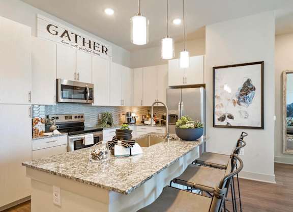 A kitchen with a granite countertop and a sign that says