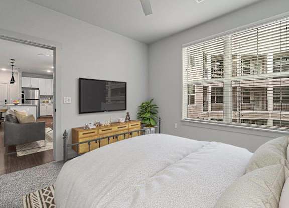 A bedroom with a large bed and a flat screen TV mounted on the wall.