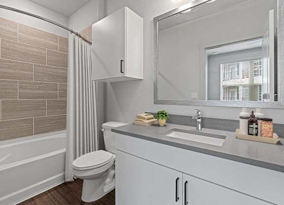 A bathroom with a toilet, sink, and a mirror.