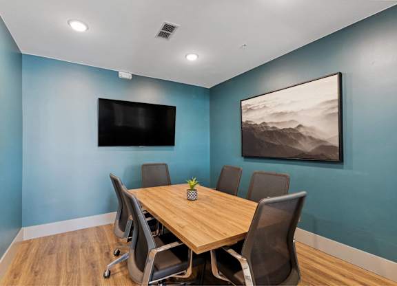 A conference room with a wooden table and chairs.