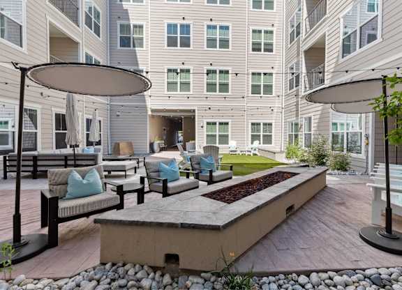 A patio area with a bench, table, and umbrella.