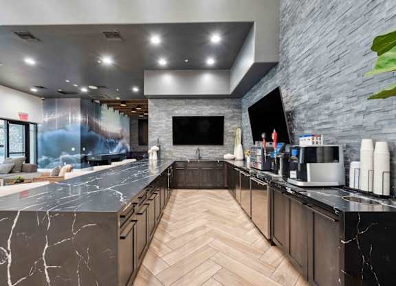 A modern kitchen with a marble countertop and wooden cabinets.