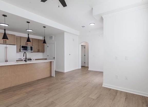A kitchen with a refrigerator, microwave, and oven.