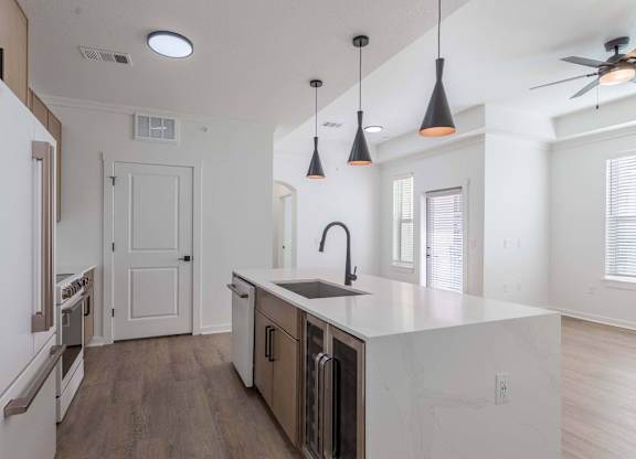 A kitchen with a white counter top and a ceiling fan.