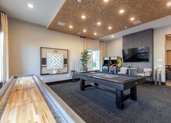 A room with a long wooden table and a television on the wall.