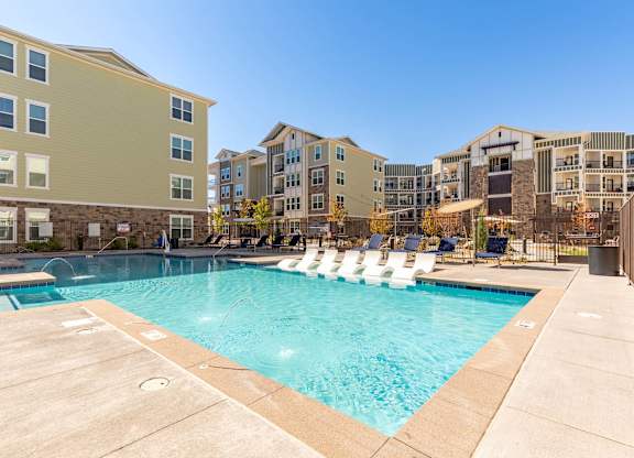 A swimming pool in front of apartment buildings.