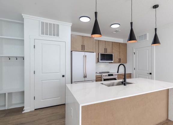 A kitchen with a white countertop and a sink.