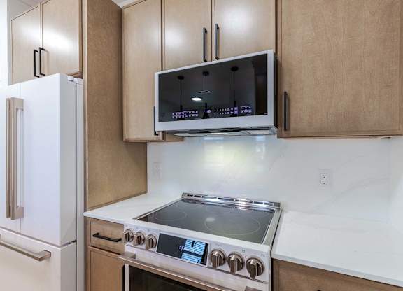 A modern kitchen with a stainless steel stove and a white refrigerator.