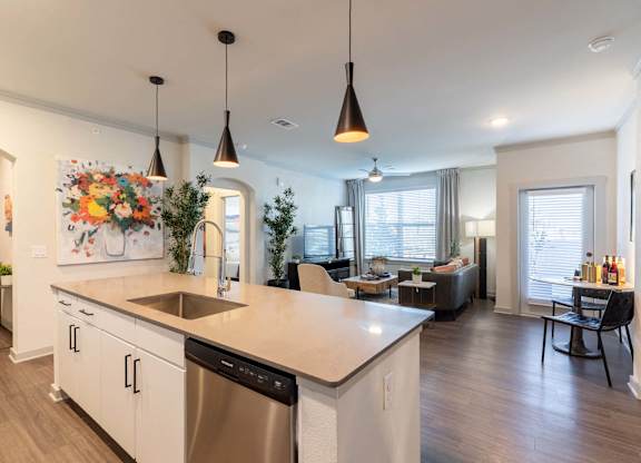 A modern kitchen with a large island and pendant lights.