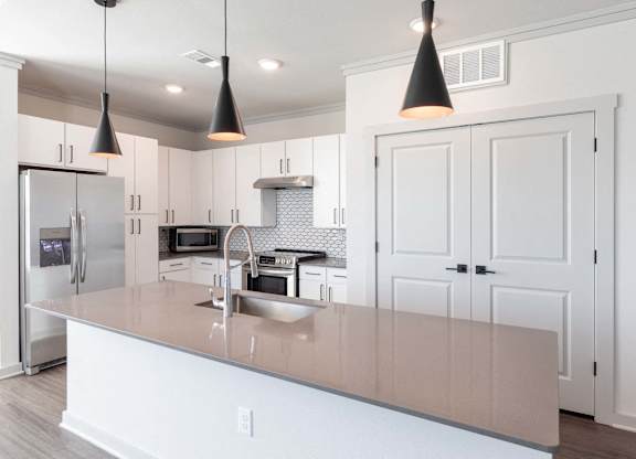A kitchen with a white counter and cabinets.