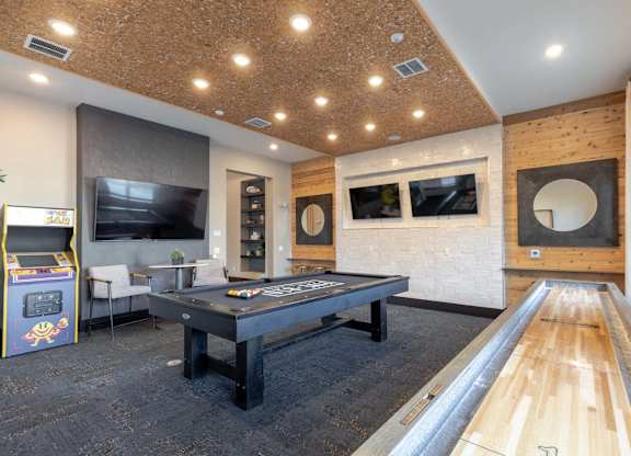 A room with a pool table and a foosball table.