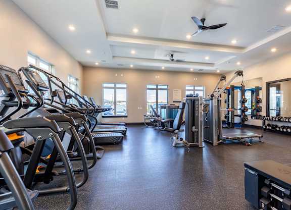 A spacious gym with treadmills, elliptical machines, and other exercise equipment.