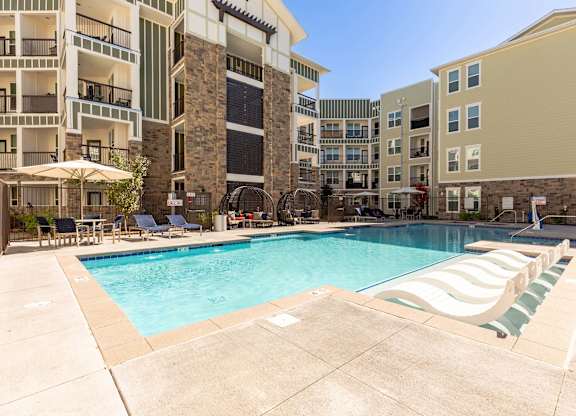 A large swimming pool surrounded by apartment buildings.