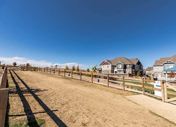 A row of houses with a fence in front of them.