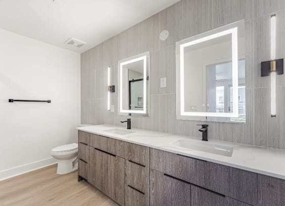 A bathroom with a toilet, sink, and mirror.