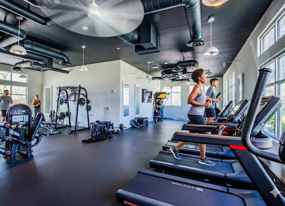 A gym with people working out and treadmills.