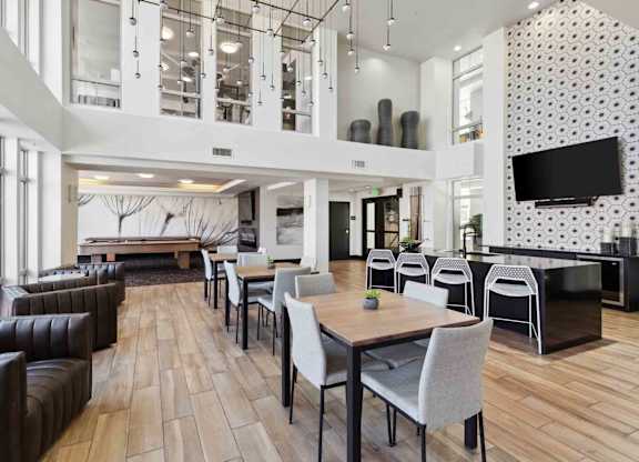 a common room with tables and chairs and a foosball table