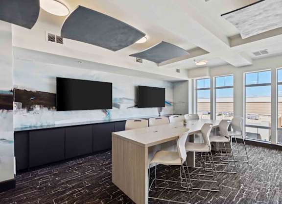 a meeting room with large windows and a long table with chairs