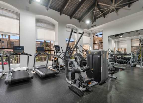 A gym with treadmills, elliptical machines, and other exercise equipment.