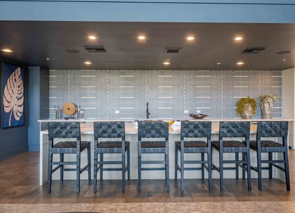 a large table with chairs in front of a wall with a geometric pattern