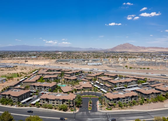 an aerial view of a neighborhood with a road and mountains in the background