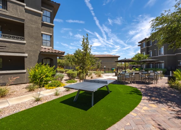 a ping pong table sits in the middle of a grassy area in front of a