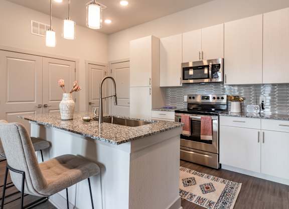 A kitchen with a bar area and a refrigerator.