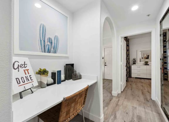 a home office with white walls and hardwood flooring