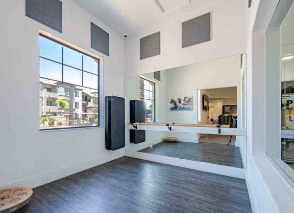 a home gym with a large window and hardwood floors