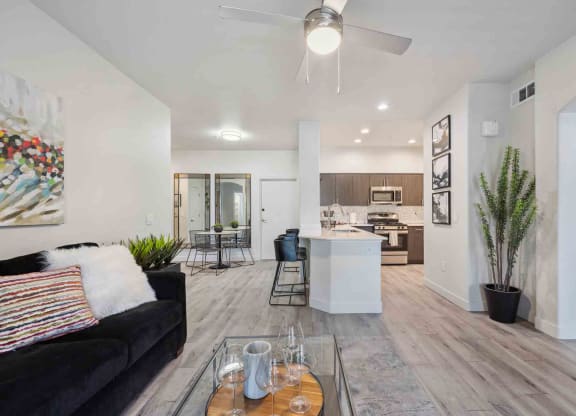 a living room with a couch and a coffee table in front of a kitchen