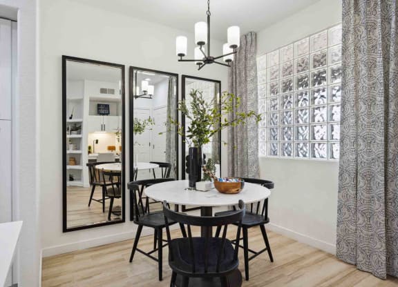 a small dining room with a round dining table and black chairs