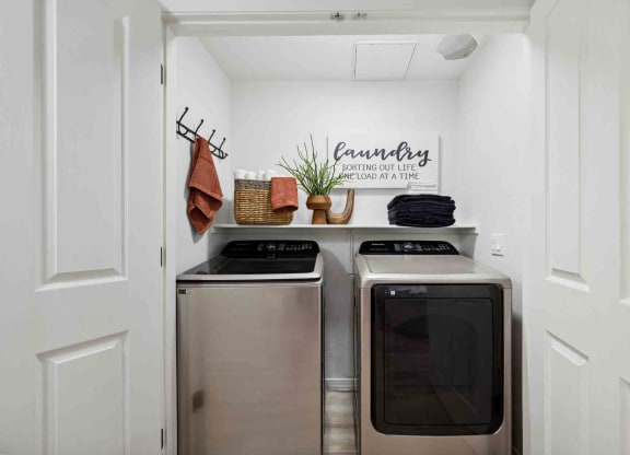 a laundry room with two washers and a dryer