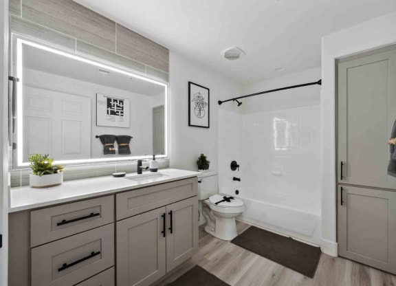 an all white bathroom with gray cabinets and a black shower curtain