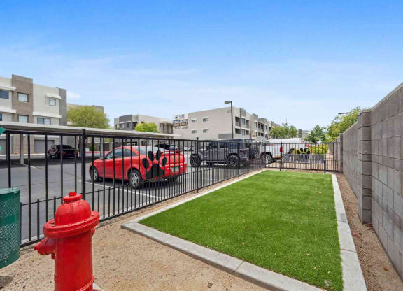 a fire hydrant sits on a small patch of grass in front of an apartment complex