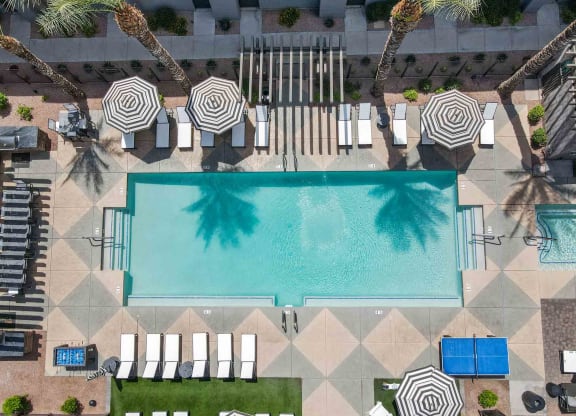 aerial view of a resort pool surrounded by lounge chairs and umbrellas