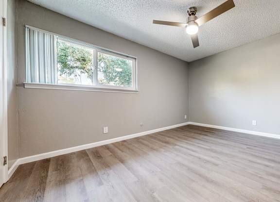 A room with a ceiling fan and a window with blinds at Pennsylvania Place, Davis, CA
