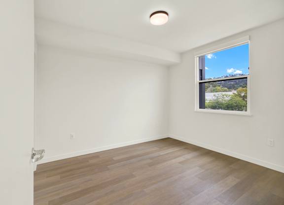 A room with a window and a wooden floor at 26FIFTY Apartments, Berkeley, CA, 94704