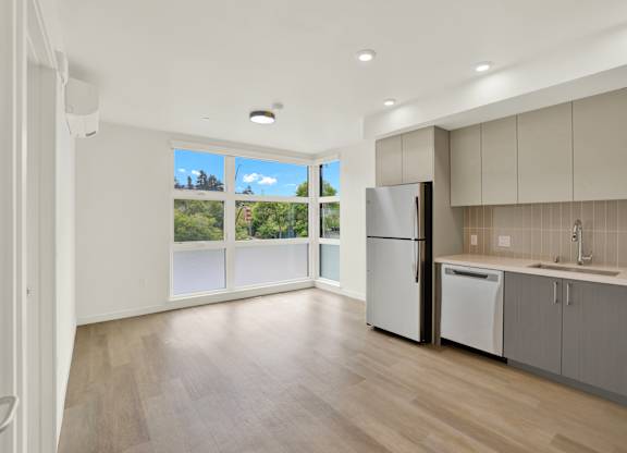 A kitchen with a refrigerator and a washing machine at 26FIFTY Apartments, California