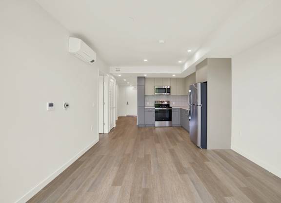 A modern kitchen with a refrigerator, oven, and sink at 26FIFTY Apartments, Berkeley, CA, 94704