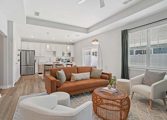 A modern living room with a kitchen in the background. at Zora University, Charlotte, 28213