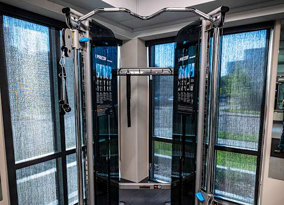 a fitness room with cardio machines and a window
