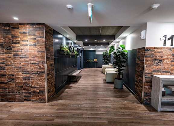 a view of a hallway with wooden floors and brick walls