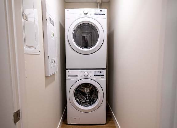 a white washer and dryer in a narrow laundry room