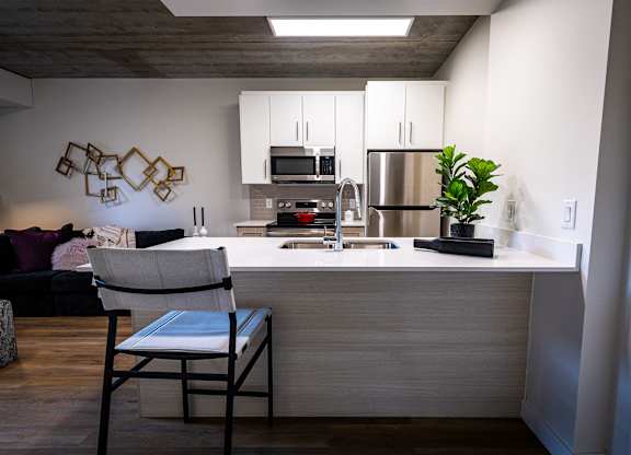 a kitchen with a counter and a chair in a living room