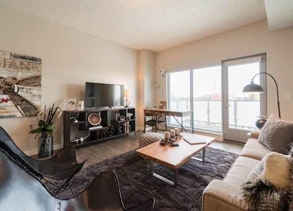 A living room with a couch, chair, and television.