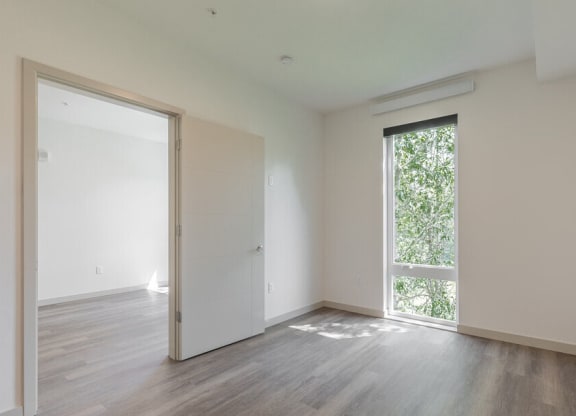 an empty room with a large window and a door